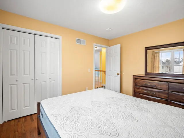 a bedroom with a bed and a dresser next to a window