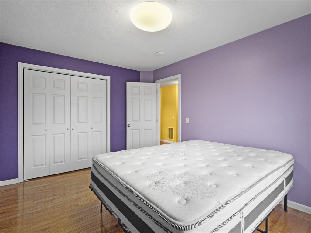 36 Knowlton Circle, Unit 36 Upton, MA 01568 - Photo 32 of 39 a room with a bed and wooden floor