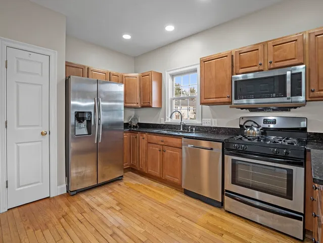 a kitchen with stainless steel appliances granite countertop a stove a refrigerator and a microwave