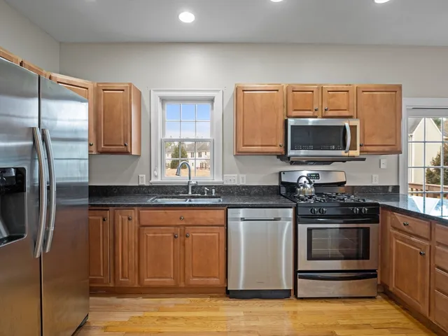 a kitchen with stainless steel appliances a stove a sink and a microwave