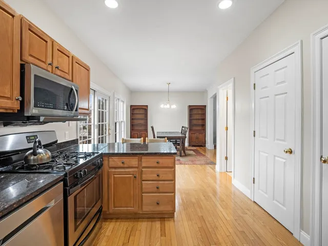 a kitchen with stainless steel appliances granite countertop a stove and a wooden floors