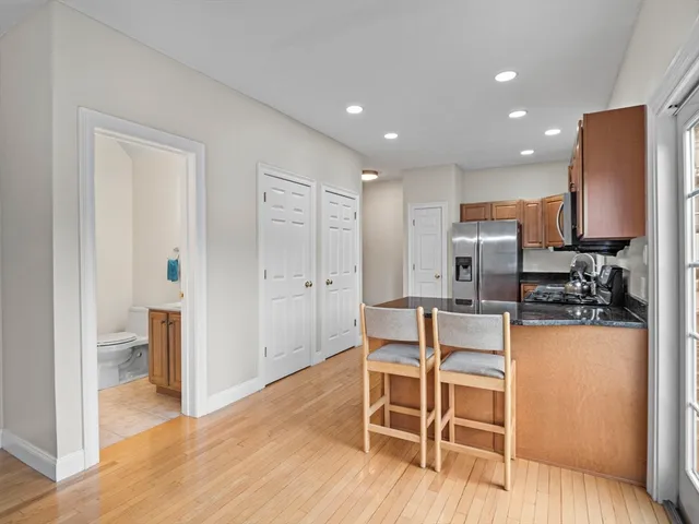 a kitchen with stainless steel appliances kitchen island granite countertop a refrigerator and cabinets