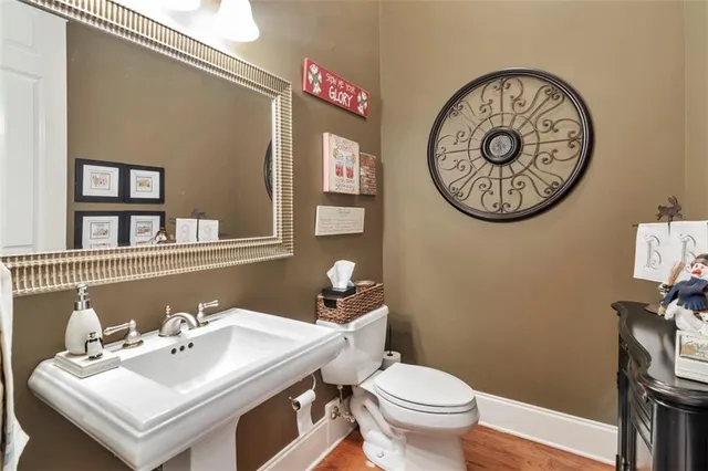 a bathroom with a sink a toilet a mirror and shower