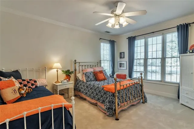 a dining hall with couches a fireplace and a chandelier with kitchen view