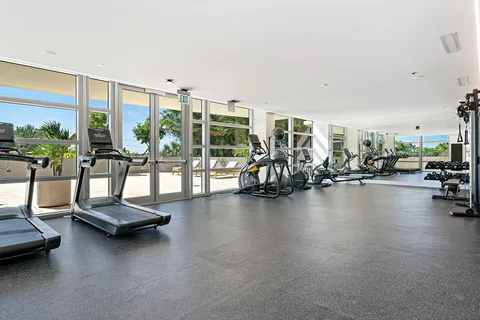 a view of a room with gym equipment and floor to ceiling window