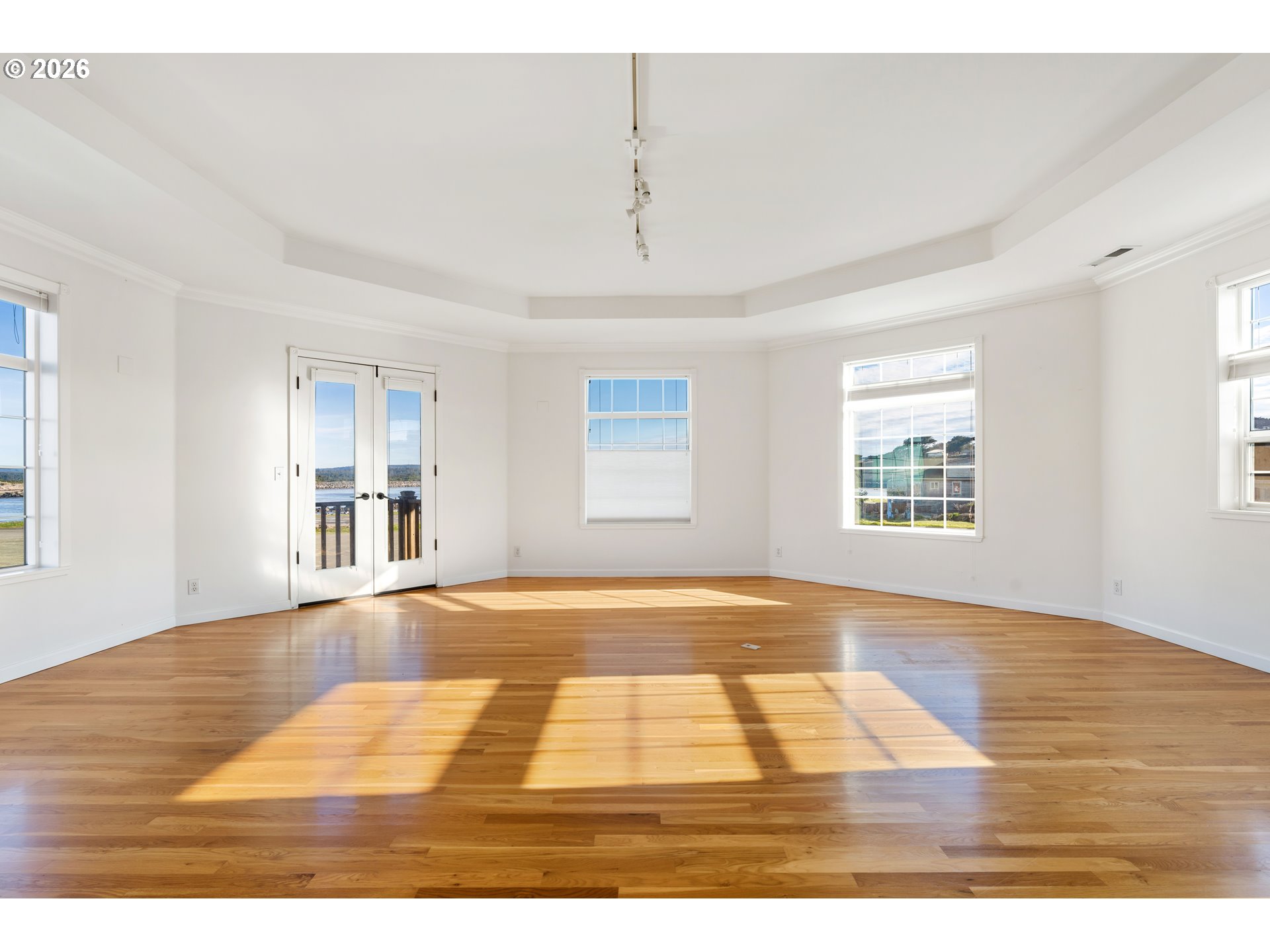 323 Madison Avenue Bandon, OR 97411 - Photo 16 of 43 a view of an empty room with wooden floor and windows