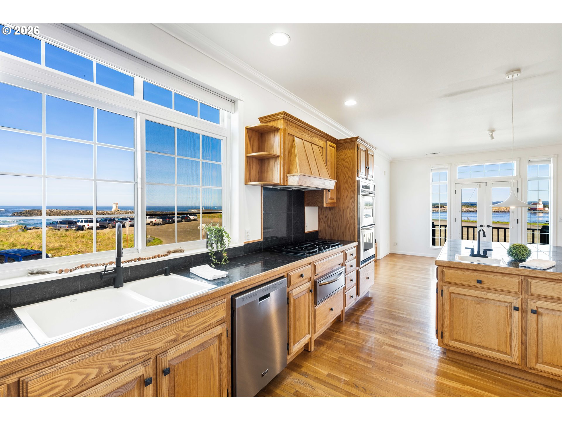 323 Madison Avenue Bandon, OR 97411 - Photo 21 of 43 a kitchen with stainless steel appliances granite countertop a stove a sink and a microwave