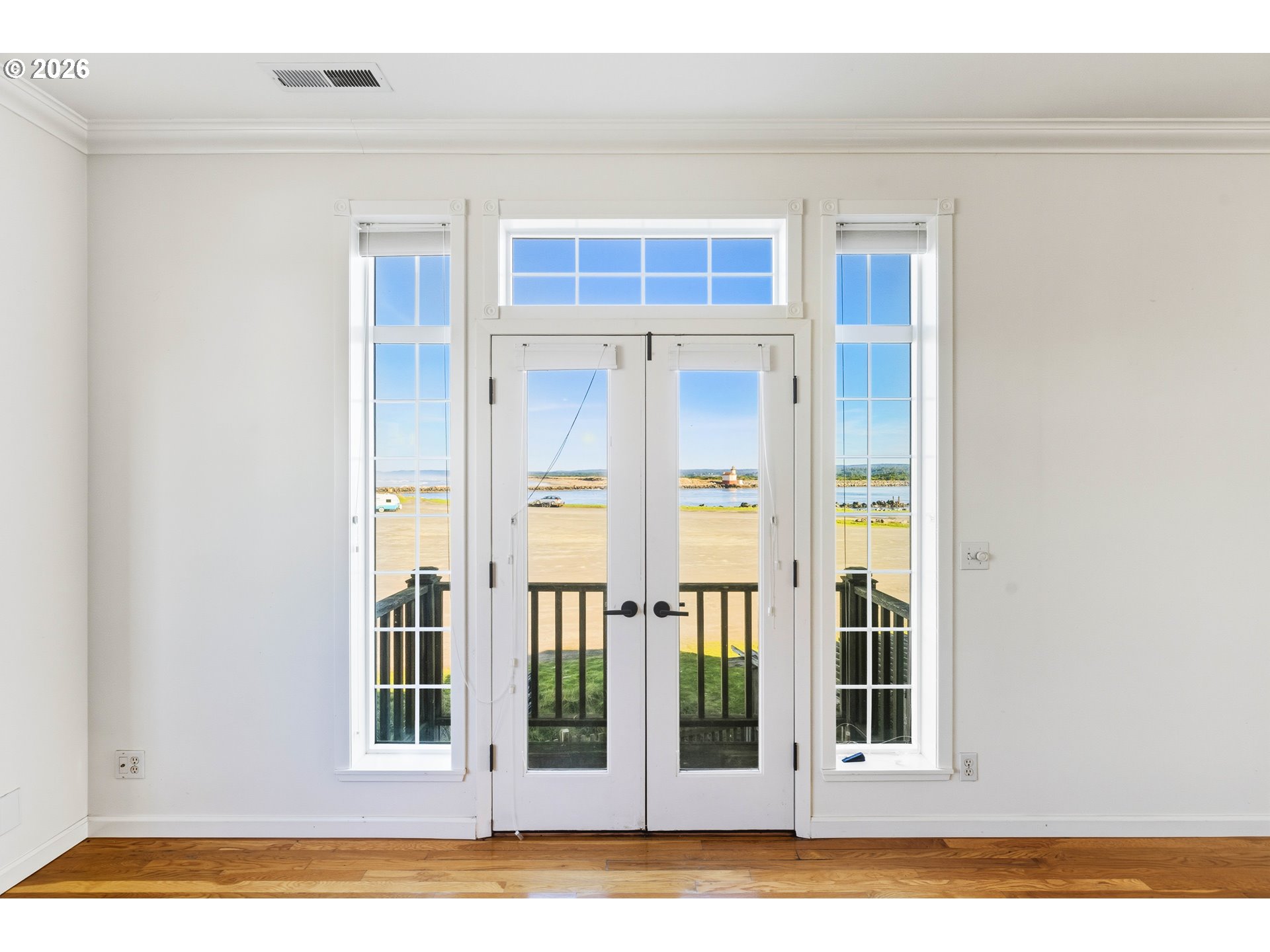 323 Madison Avenue Bandon, OR 97411 - Photo 26 of 43 a view of a bedroom with wooden floor and windows