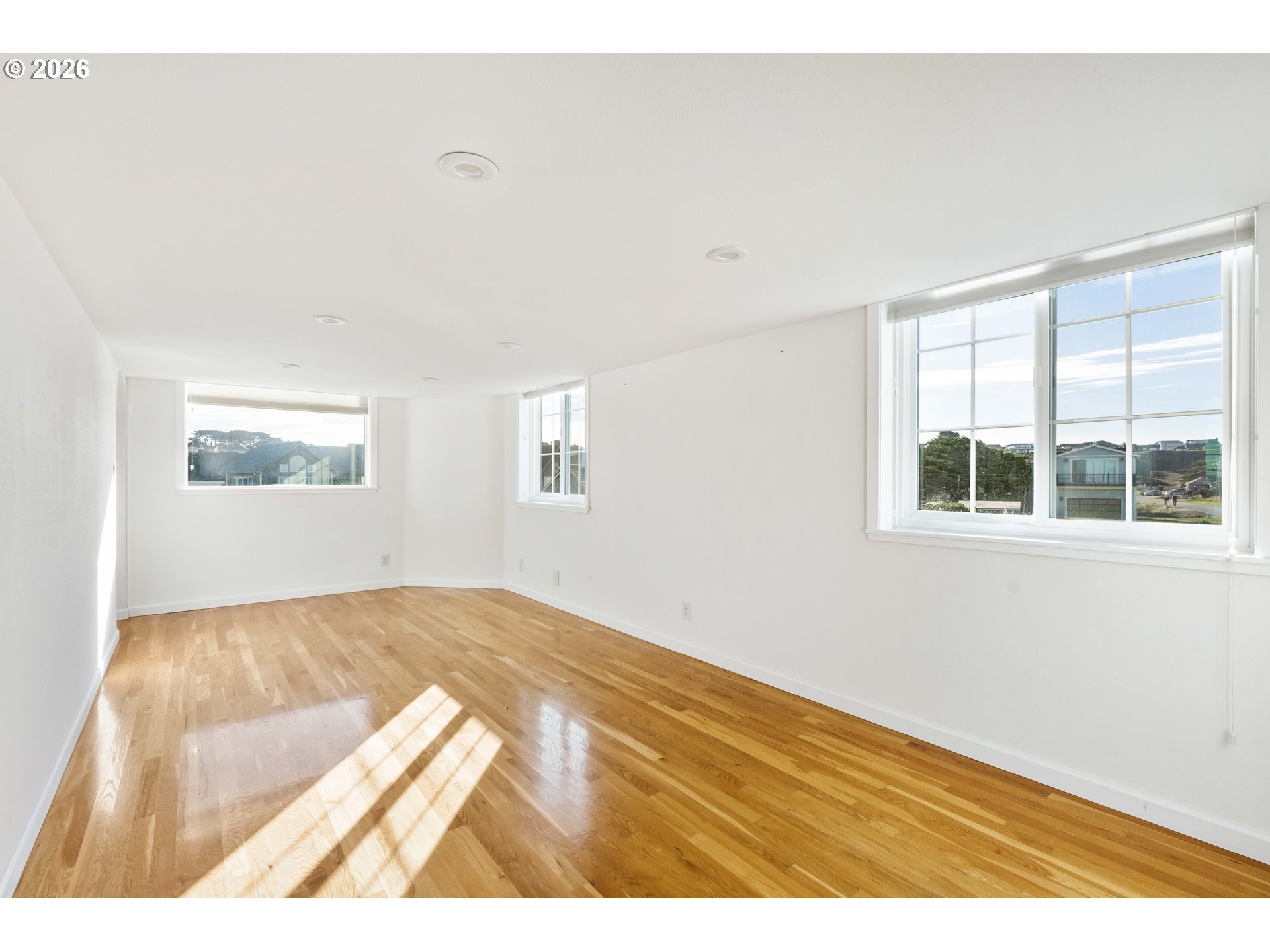 323 Madison Avenue Bandon, OR 97411 - Photo 28 of 43 a view of an empty room with wooden floor and a window