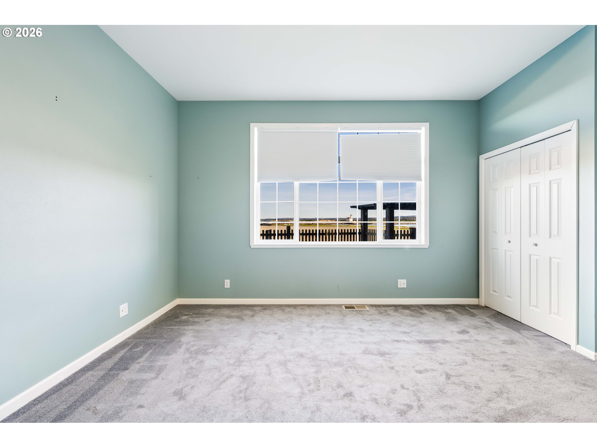 323 Madison Avenue Bandon, OR 97411 - Photo 34 of 43 an empty room with wooden floor and windows