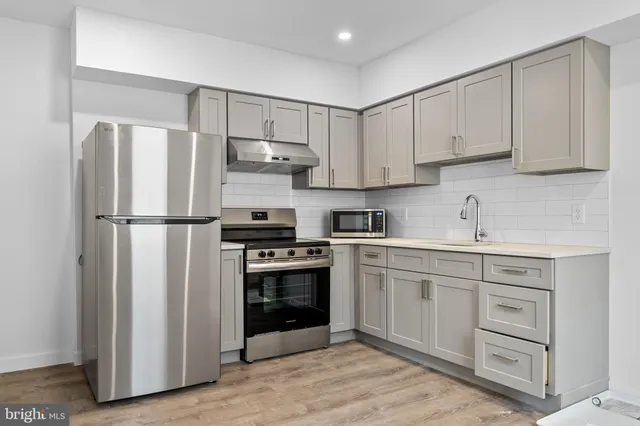 a kitchen with cabinets stainless steel appliances and a sink