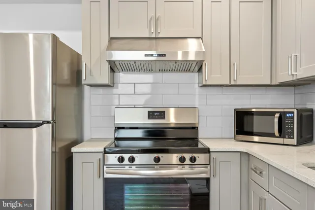 a stove top oven sitting inside of a kitchen