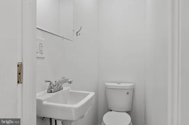 a bathroom with a toilet sink and mirror