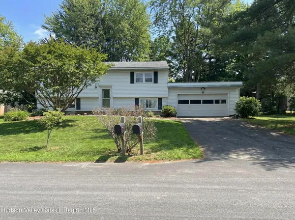 a front view of a house with a yard and trees