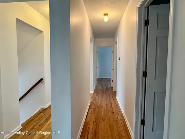 an empty room with wooden floor cabinet and windows