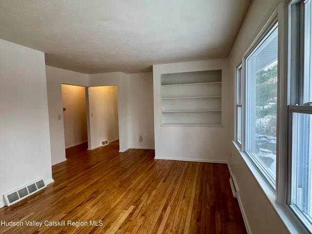 a view of a room with wooden floor and iron stairs