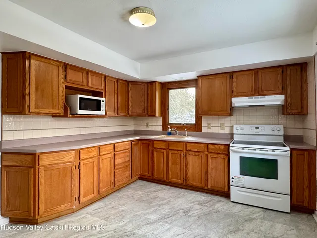 a kitchen with stainless steel appliances granite countertop a stove sink and microwave