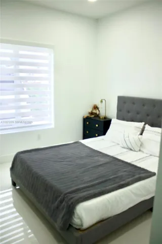 a bed sitting in a bedroom next to a window