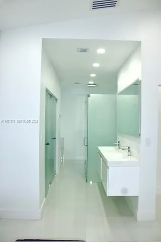 a bathroom with a sink mirror and a shower