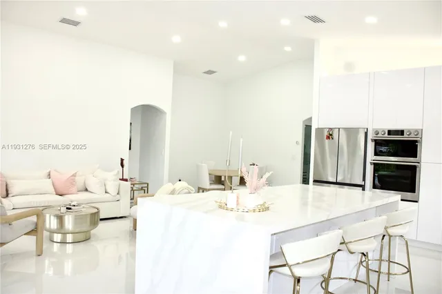 a dining room with furniture and stainless steel appliances