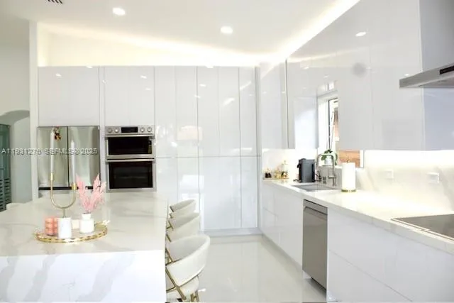 a kitchen with stainless steel appliances kitchen island granite countertop a sink and cabinets