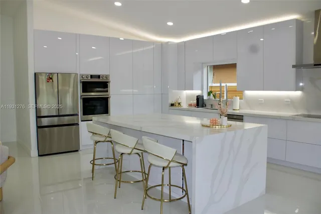 a kitchen with stainless steel appliances kitchen island granite countertop a table and chairs