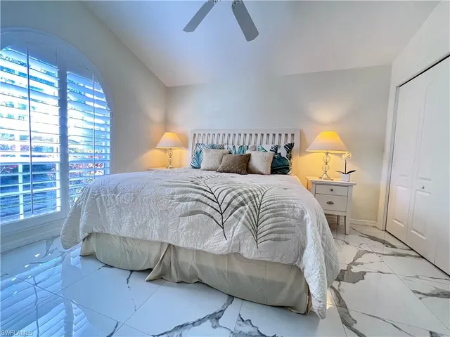 a bedroom with a bed a lamp and a window