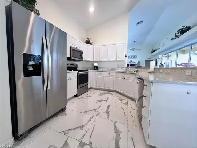 a kitchen with stainless steel appliances granite countertop a refrigerator sink and stove