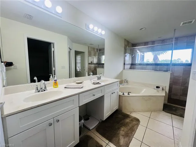 a spacious bathroom with a bathtub sink and mirror