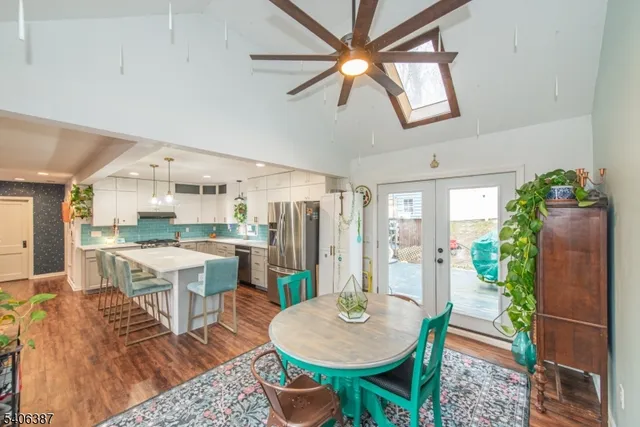 a open dining room with furniture a rug and wooden floor
