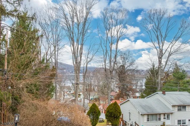 a view of residential houses with yard and trees