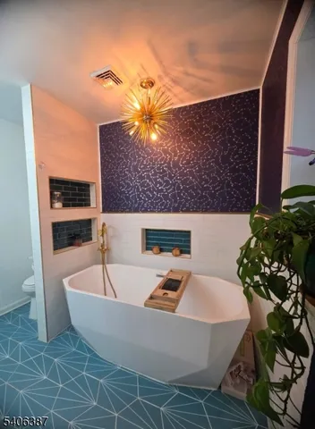 a living room with furniture a chandelier and a rug