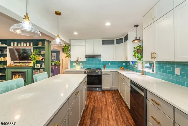 a large kitchen with a large center island wooden floor stainless steel appliances and cabinets