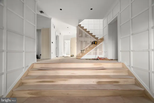 a view of an empty room with windows and a kitchen