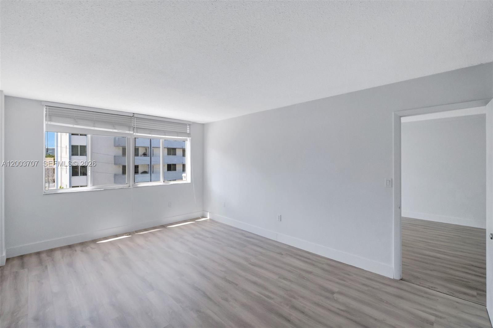 1345 Lincoln Road, Unit 501 Miami Beach, FL 33139 - Photo 17 of 33 an empty room with wooden floor and windows
