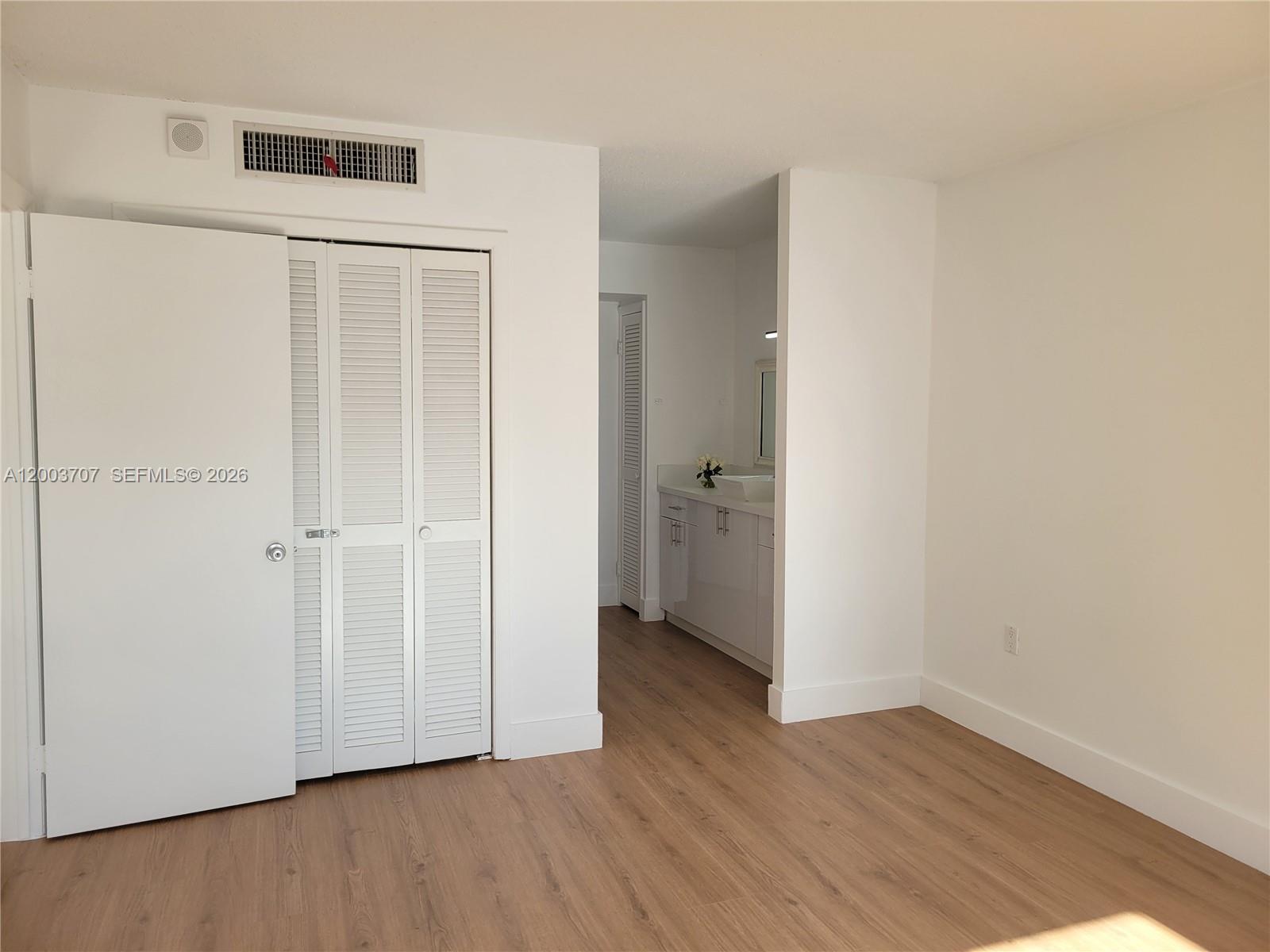 1345 Lincoln Road, Unit 501 Miami Beach, FL 33139 - Photo 19 of 33 an empty room with wooden floor and a bathroom