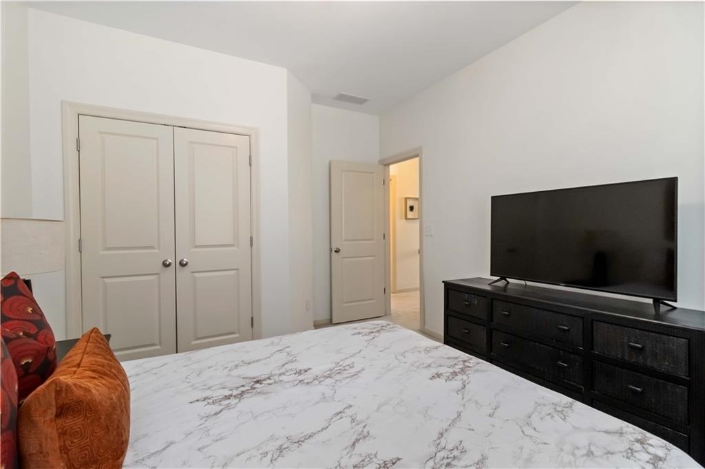 6233 Huntington Ridge Road Mableton, GA 30126 - Photo 33 of 50 a bedroom with a bed and a flat screen tv