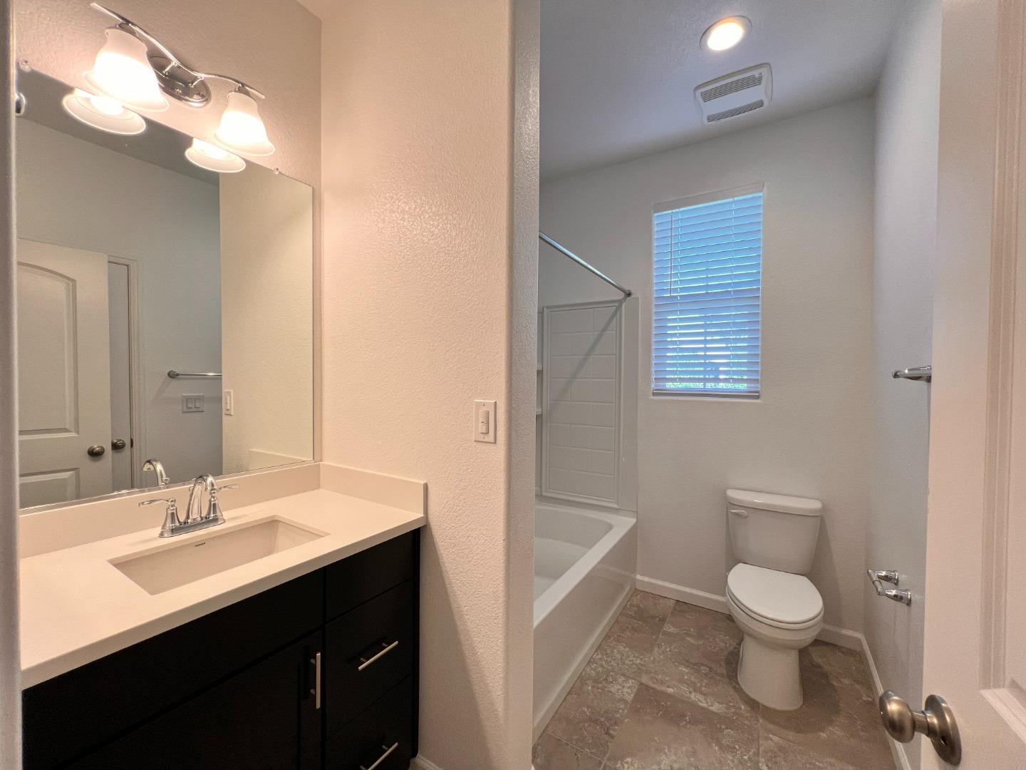 8362 Lemberger Way Sacramento, CA 95829 - Photo 19 of 28 a bathroom with a toilet sink a mirror and shower