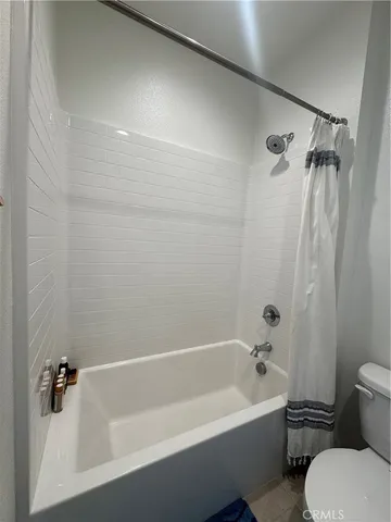 a bathroom with a bathtub shower sink and mirror