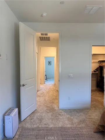 a living room with furniture kitchen view and a wooden floor