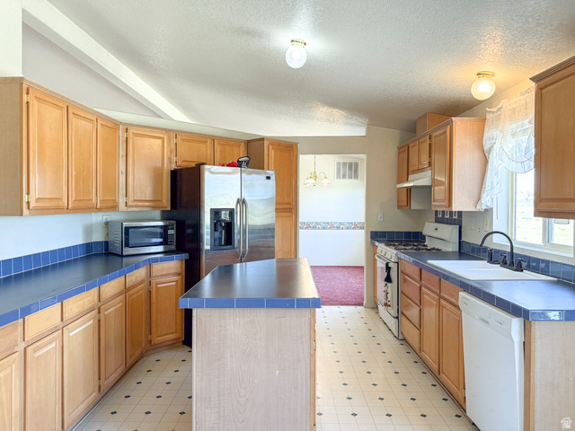 141 South 100 East Emery, UT 84522 - Photo 8 of 17 Kitchen featuring light wood cabinetry, blue tiled countertops, a central island, and patterned tile flooring