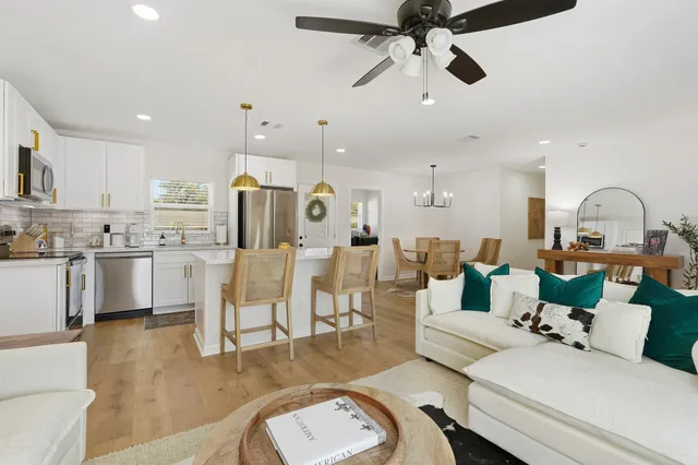 a living room with lots of furniture and kitchen view