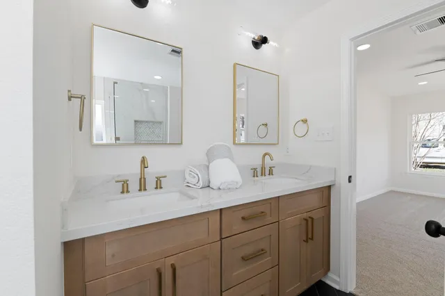 a bathroom with double sink and a mirror