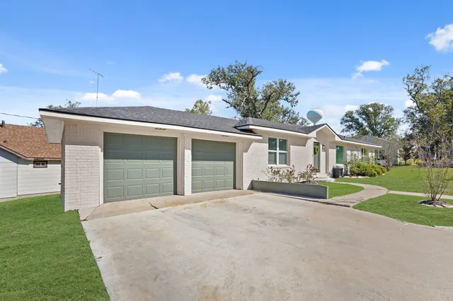 a view of a house with a yard and potted plants
