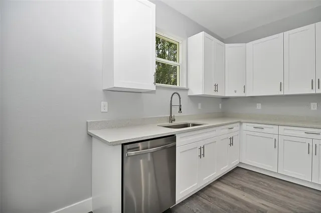 a kitchen with a sink cabinets and window