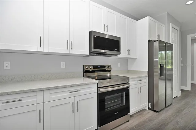 a kitchen with white cabinets and stainless steel appliances