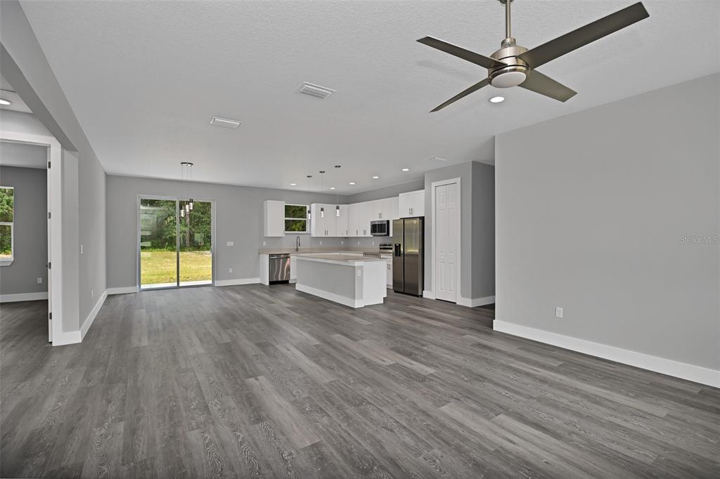 6237 Southwest 143rd Street Ocala, FL 34473 - Photo 15 of 35 a view of a livingroom with wooden floor a ceiling fan and windows