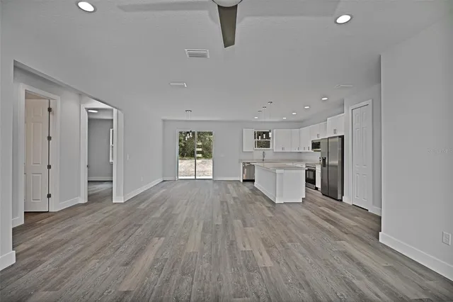 a view of a kitchen with wooden floor and a refrigerator