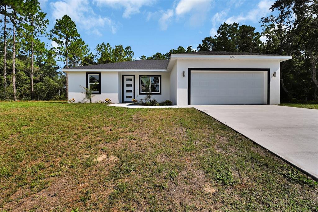 6237 Southwest 143rd Street Ocala, FL 34473 - Photo 5 of 35 a front view of a house with a yard and garage
