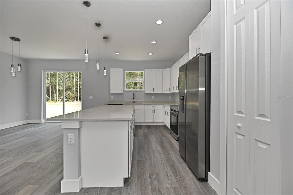 6237 Southwest 143rd Street Ocala, FL 34473 - Photo 10 of 35 a kitchen with a refrigerator a sink and wooden floor
